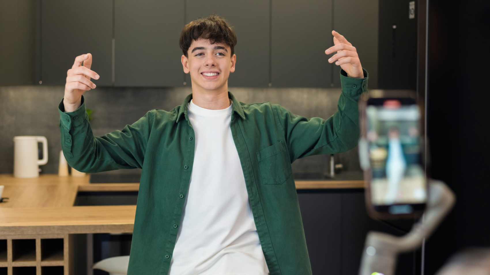 A person recording a young dancing man blogger influencer on smartphone on a stabiliser in a studio