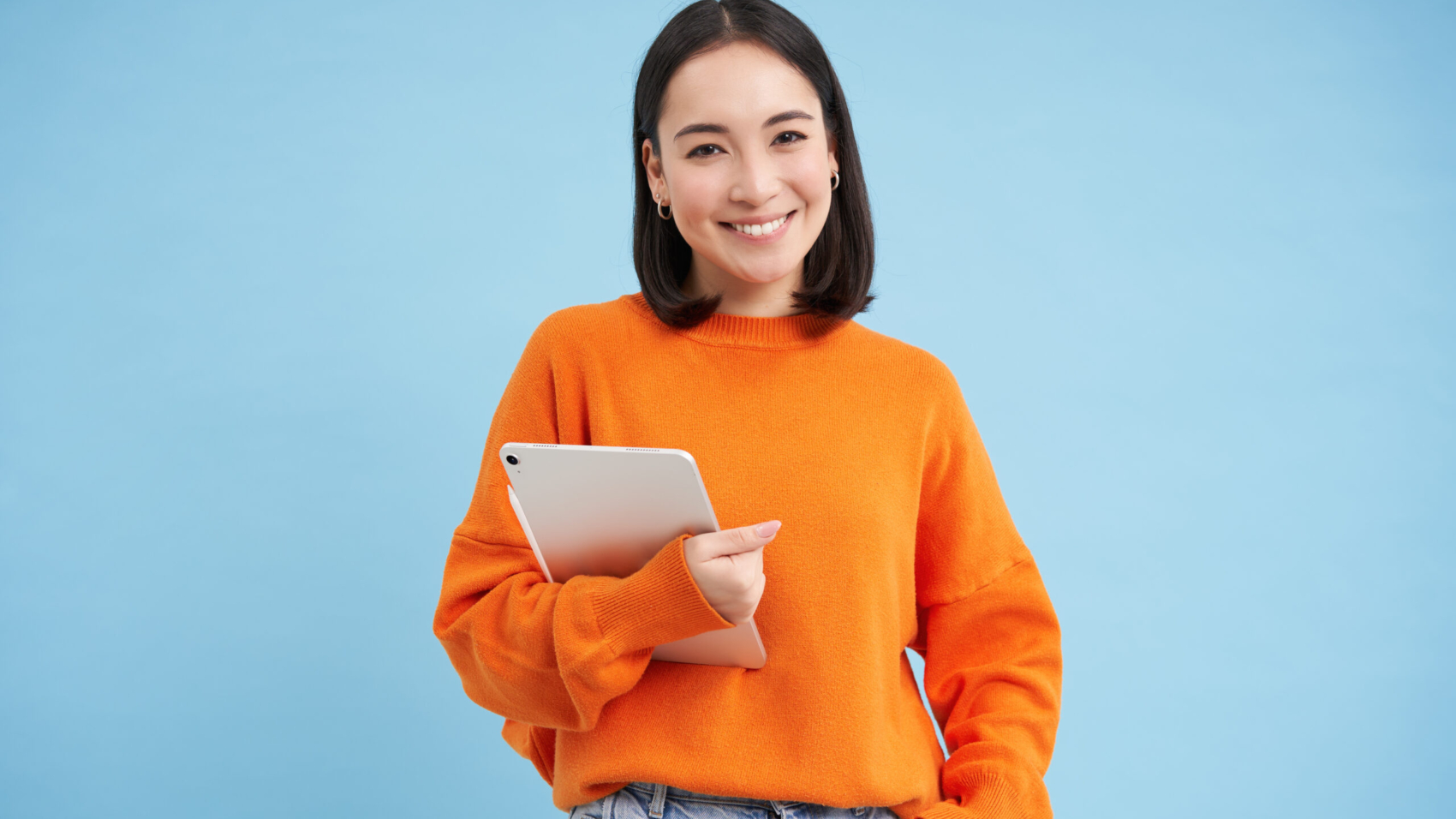 Smiling modern woman with tablet, looking confident, student with her gadget, standing over blue background.